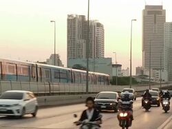 Rush hour busy traffic driving on highway and skytrain pass skyscraper Stock Footage