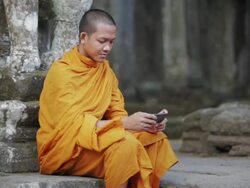 MS A Buddhist monk uses a smartphone on the steps of an ancient temple in Angkor Wat / Siem Reap, Cambodia Stock Footage