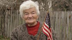 Senior Woman Holding American Flag Looking at Camera and Smiling Stock Footage