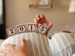 A pregnant women using blocks to spell the word 2015 on her stomach. Stock Footage
