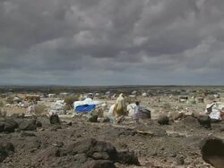 WS PAN Woman with her girl dressed in white dress at Refugee Camp and cloudy sky / Djibouti Stock Footage