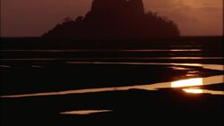A low sun silhouettes Mt. Saint Michel in Normandy, France. Stock Footage