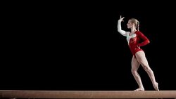 Female gymnast performing routine on balance beam Stock Footage