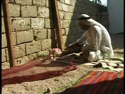MS Bedouin man sitting on floor, mending fishing nets, Egypt Stock Footage