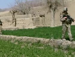 WS ZO Soldiers walking through landscape / Mausa Qala, Helmand Province, Afghanistan. Stock Footage