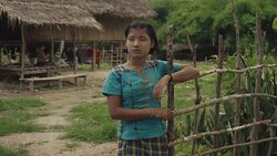 M/S Burmese teenage girl in the door of her house Stock Footage