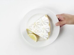 CU Woman hand entering setting down round white plate with slice of lemon meringue pie dessert / Omaha, Nebraska, United States Stock Footage