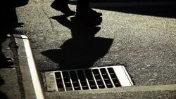 Shadows are cast on a street grate. Stock Footage