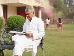 Two kids playing holi festival with his grandfather in a lawn  Stock Footage