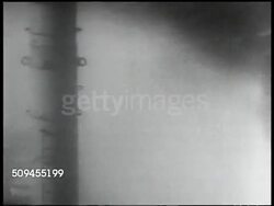 1936: HURRICANE: Storm clouds. Nautical flags on ship mast (possibly hurricane flags, dark) PAN Shoreline w/ high winds. Ship's bow w/ water moving over. VS People on ship. Newspaper w/ 'Hurricane Sweeps Florida Keys' 'Roosevelt Allots 5 Mil for Canal Instructional Video