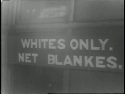 A black child and white child wash their hands with a cup of water on a sidewalk in a poor neighborhood of Capetown, South Africa in 1970. News Clip