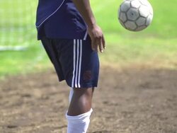 A man playing soccer on a grassy field. - Slow Motion - filmed at 240 fps Stock Footage