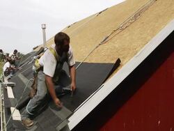 MS Shot of worker hammering on edge with other workers behind him / Chelsea, Michigan, United States Stock Footage