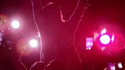 Crowd raising arms at concert with person sitting on shoulders Stock Footage