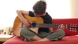 Beginner boy plays guitar at home Stock Footage