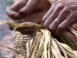 CU Shot of pygmy woman hands weaving hat out of palms / kigez, kabale, uganda Stock Footage