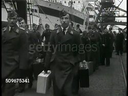 1943: NEUTRAL EXCHANGE SITE: Stern of merchant ship SS Drottningholm w/ men in uniform lining railing. VS Allied Exchange soldiers in uniform (diplomats, POWs, British, US) walking toward ramp. Volunteers serving food, coffee to waiting soldiers. WWII Instructional Video
