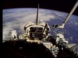 wide shot of 2 astronauts in open Space Shuttle bay in space Stock Footage