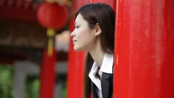 A businesswoman peers out from two bright red pillars and smiles. Stock Footage