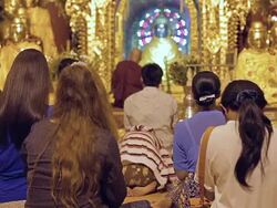 MS Shot of Men and women praying to Buddha statue (seen from behind) / Yangon, Yangon Division, Myanmar  Stock Footage