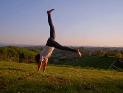 SLO MO Girl makes handstand on the meadow Stock Footage