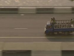 MS AERIAL TS ZI shot above bridge sunrise on road with focus on little truck transporting cows and people / Lagos, Nigeria Stock Footage