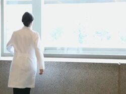 WS Female physician walking and sitting up on window sill / Seattle, Washington, USA Stock Footage