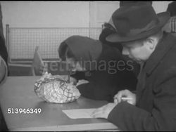 1953: REFUGEES: BERLIN, GERMANY: MS Sign in German for 'fingerprinting.' VS Various East Berlin refugees at table filling out personal history forms. Berlin Wall, occupied city Instructional Video