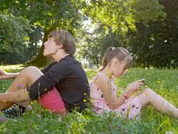 WS DS Siblings Using Modern Technology In The Park Stock Footage