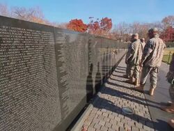 A static shot of the back of a group of soldiers slowly walking by the Vietnam War Memorial. Stock Footage