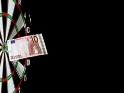 Dart with money hitting dartboard against black background, slow motion Stock Footage