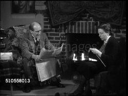 1944: DRAMATIZATION: IRISH HOME: Middle-aged couple sitting by fireplace, man reading paper, woman knitting, 'Sacred Heart' painting of Christ BG, male upset that Shaw agrees w/ his wife, Irish need training, wife making comment. Instructional Video