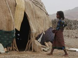 Child getting inside hut and woman getting out of it Stock Footage