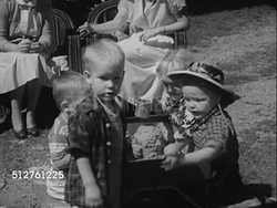 1953: TWO YEAR OLD: Outdoor bar-b-que. Children playing w/ others at raised sand box, boy in cowboy hat wanting what other has, attempting to take it from him, gets it. [SOT Dr. Spock saying two year old will either give in or defend item.]... Instructional Video