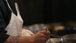Saute chef samples simmering sauce in restaurant kitchen Stock Footage