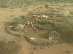 Wide Shot - Maasai wear colorful attire as they gather in their village / Kenya Stock Footage