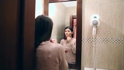 Beautiful young woman applying cosmetics for going out. Stock Footage