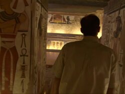 Medium, pan-right - A man views murals depicting Egyptian life Stock Footage
