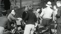 1942 MONTAGE Townsfolk on bicycles gathering outside a building to volunteer harvesting crops in the countryside in World War II / United Kingdom Stock Footage