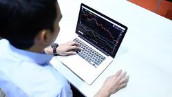 Business people using laptop and reviewing blueprints at desk Stock Footage