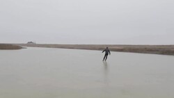 Young man ice skating on frozen pond in winter in rural Montana, USA. Stock Footage