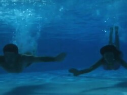Good Looking Young Couple swimming underwater in pool Stock Footage