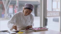 Baker carefully places tangerine slice on gourmet cake Stock Footage