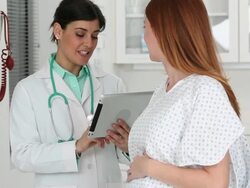 MS TU Doctor Talking to Pregnant Woman, Reviewing Electronic Medical Records / Richmond, Virginia, USA Stock Footage