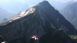 BASE jumper in mid air flight from mountain summit Stock Footage