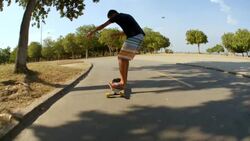 Brazilian teen skates Rio street on longboard in slow motion Stock Footage