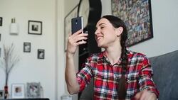 Young woman talking on a video chat on a smart phone at home Stock Footage