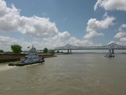 MS POV View of tugboats flowing on mississippi river in front of bridge / New Orleans, Louisiana, United States Stock Footage