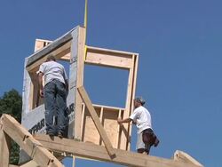 WS ZO Carpenters and crane operator placing window frame while framing an energy efficient post / Grass Lake, Michigan, USA     Stock Footage