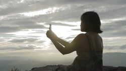 Asian woman taking photo on the cliff by smartphone Stock Footage
